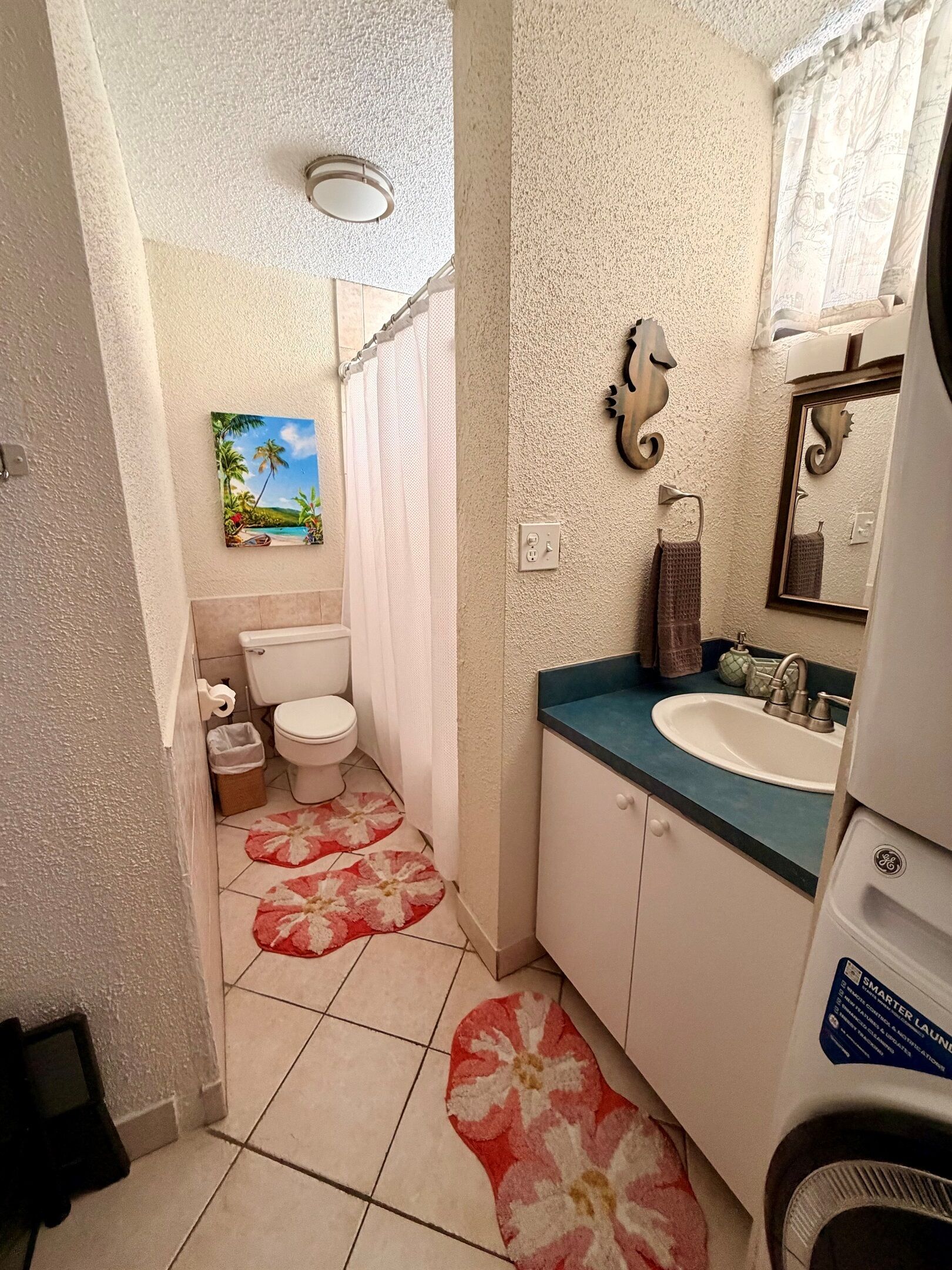 Une petite salle de bain comprenant des toilettes, un lavabo et un rideau de douche.