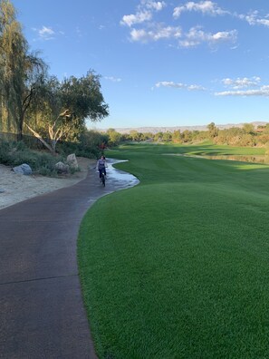 Stroll along the well-maintained golf course with a clear pathway for walking.