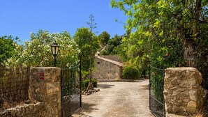 A stone gate with a sign reading 'LA COMA,' leading to a stone pathway.