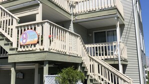 Un immeuble à plusieurs étages doté d’un balcon, d’une enseigne indiquant « 9, allée Everett » et d’un petit jardin.