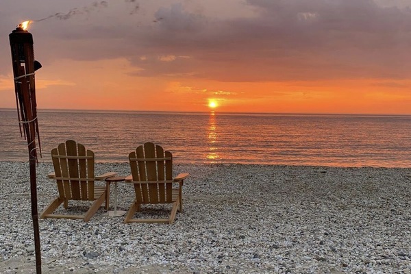 Ranta lähistöllä, aurinkotuoleja, rantapyyhkeitä