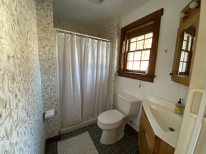 Ein Badezimmer mit Toilette, Waschbecken und Duschvorhang.