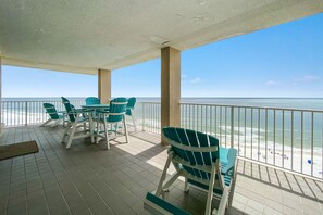 Un espace extérieur abrité, avec vue sur la plage, comprenant une table et des chaises.