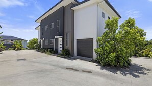 A modern two-story house with a garage, surrounded by a driveway and lush greenery. - Top Town Terrace - short walk to town center (Woolgoolga)