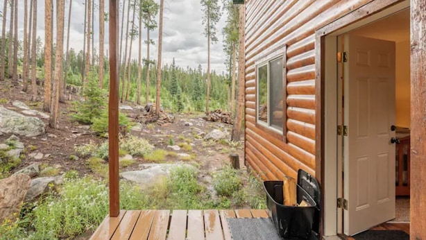 A log cabin with a wooden deck and a door leading to the interior. - Red Feather Woodland Retreat, Family and Pet Friendly, 4 beds (Red Feather Lakes)