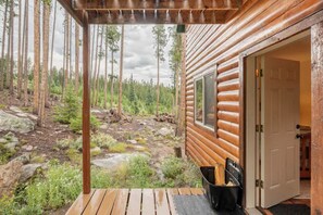 A log cabin with a wooden deck and a door leading to the interior. - Red Feather Woodland Retreat, Family and Pet Friendly, 4 beds (Red Feather Lakes)