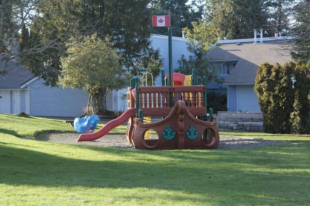 A playground with a slide and a Canadian flag.