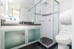 Habitación doble estándar | Baño | Regadera, toallas, jabón, papel de baño 