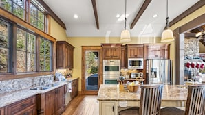 A spacious kitchen with wooden cabinets, granite countertops, and stainless steel appliances. - Renowned Architect! VIEWS/Theatre/Game/HotTub/FirePit/Harry Potter (Gatlinburg)