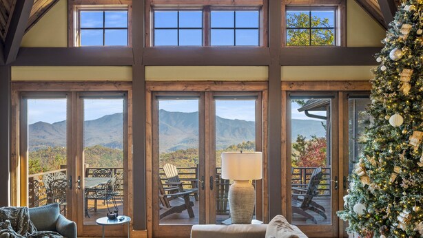 A cozy room with a large window overlooking mountains, a Christmas tree, and a fireplace. - Renowned Architect! VIEWS/Theatre/Game/HotTub/FirePit/Harry Potter (Gatlinburg)