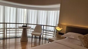A hotel room with a bed, a round table, a chair, and a balcony with curtains. - Shenzhen Ruili Hotel (Window of the World Baishizhou Subway Station) (Shenzhen)