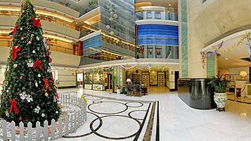 A spacious atrium with a large Christmas tree, multiple levels, and a central reception area.