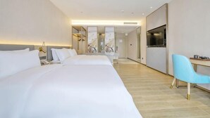 A hotel room with two beds, a desk, a chair, a TV, and a kitchen area. - Shenzhen Ruili Hotel (Window of the World Baishizhou Subway Station) (Shenzhen)