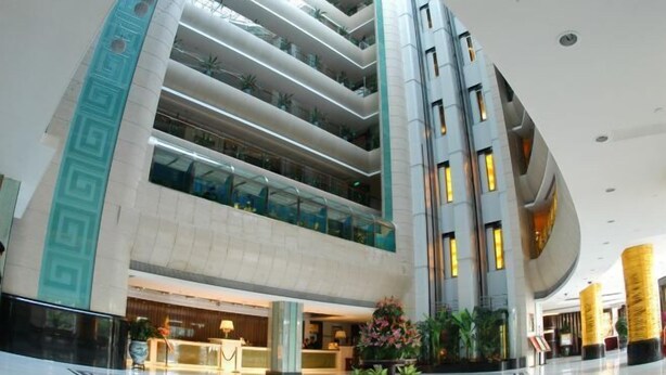 A modern hotel lobby with multiple floors, a reception desk, and a central atrium with plants. - Shenzhen Ruili Hotel (Window of the World Baishizhou Subway Station) (Shenzhen)