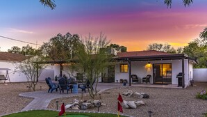 Una proprietà residenziale con patio, posti a sedere all'aperto e un piccolo giardino.