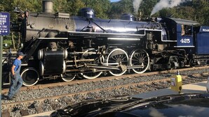 Een stoomlocomotief met het nummer 425 op een spoorlijn.