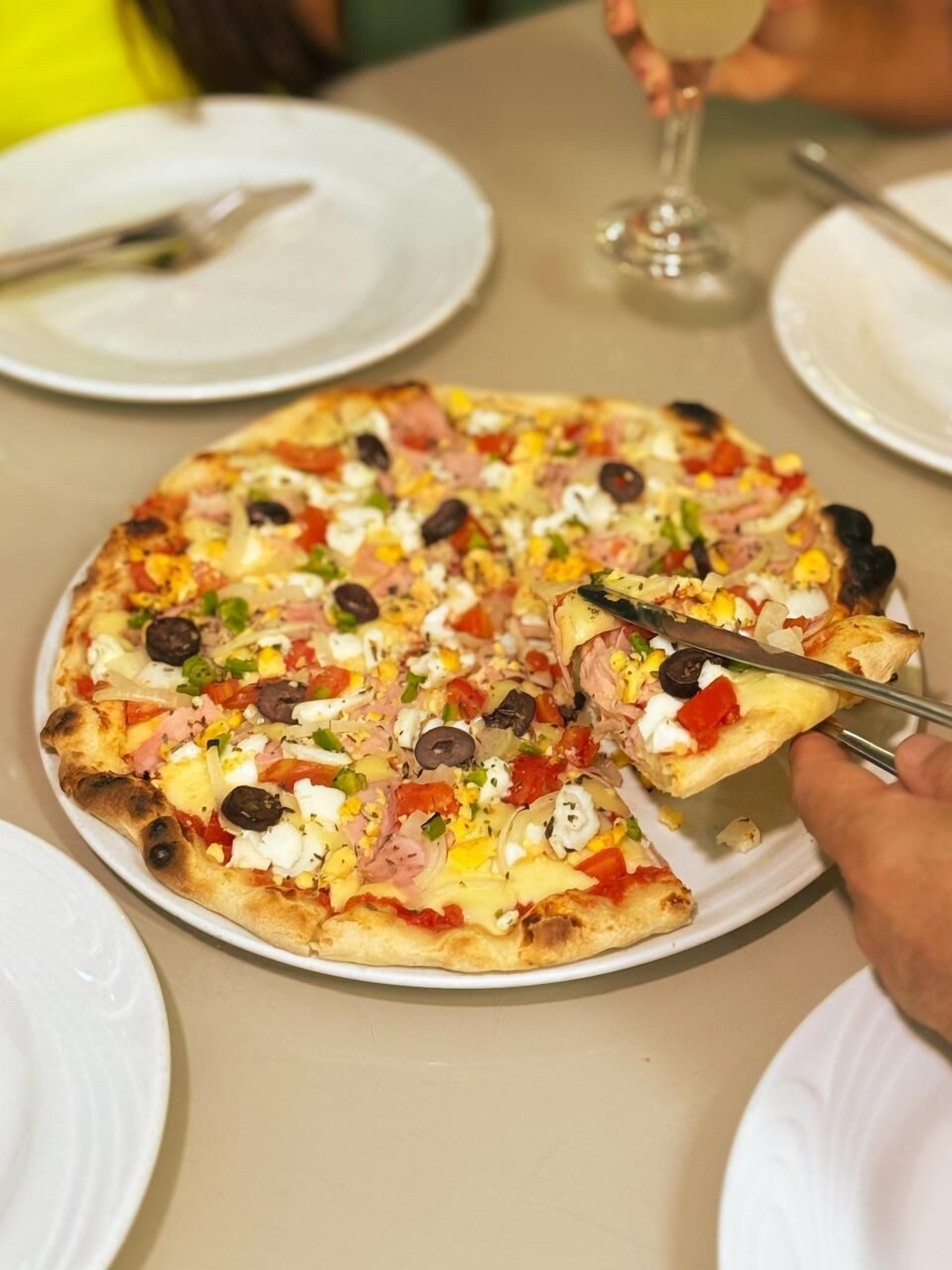 A pizza with various toppings on a white plate.