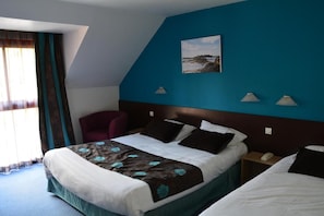 A hotel room with a large bed, a chair, a nightstand with a phone, and a painting on the wall. - Hotel Lucotel (Lanvollon)