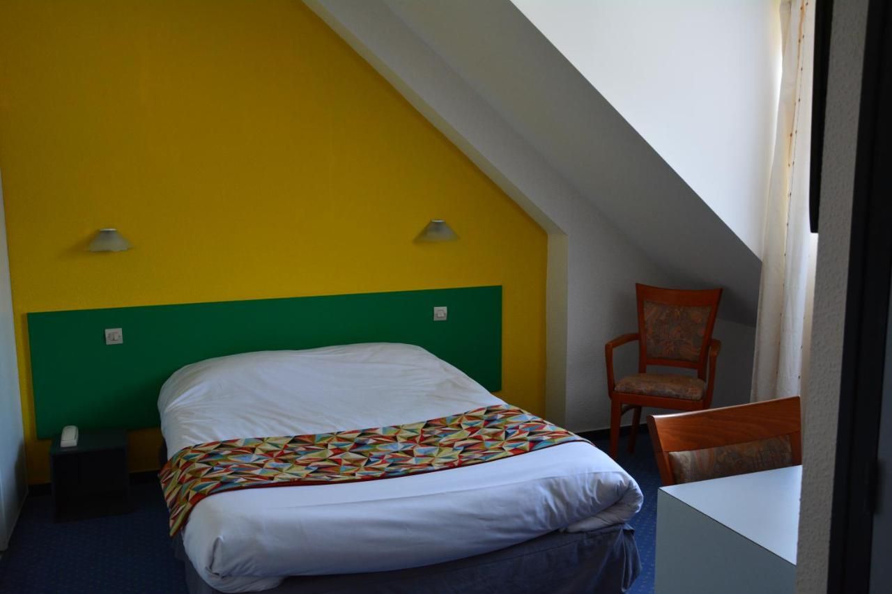 A room with a bed, a chair, and a table.