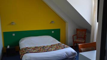A room with a bed, a chair, and a table.