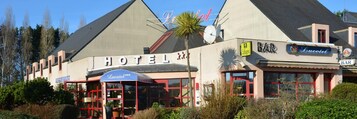 Um hotel com uma placa grande, um bar e um restaurante.