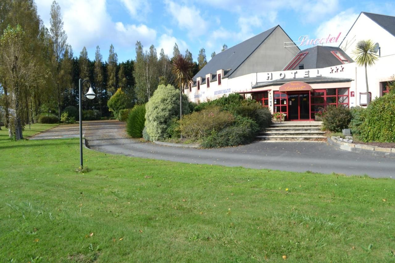 A hotel with a restaurant, a red entrance, and a well-maintained garden.