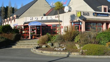 A hotel with a prominent 'HOTEL' sign, a bar, and a restaurant named 'Lucotel'.