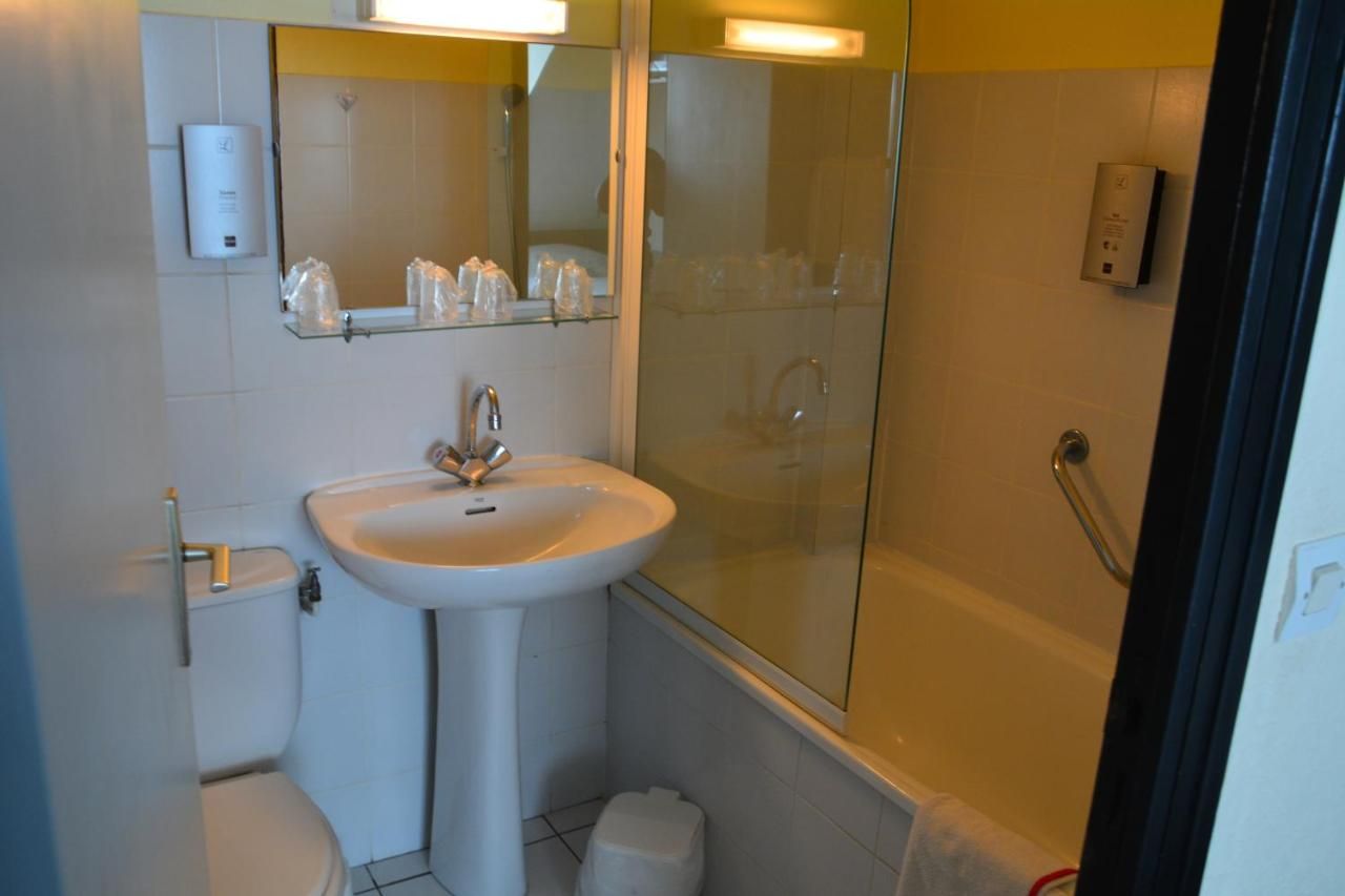 A bathroom with a sink, toilet, and glass shower enclosure.