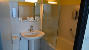 A bathroom with a sink, toilet, and glass shower enclosure. - Logis Hotel Lucotel (Lanvollon)