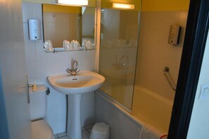 Ein Badezimmer mit Waschbecken, Toilette und einer Duschkabine aus Glas.