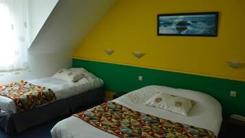 A hotel room with two beds, a green and yellow wall, a framed picture of the ocean, and a window with curtains.