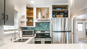 Una cocina moderna con electrodomésticos de acero inoxidable, horno empotrado y microondas.