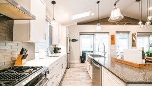 A modern kitchen with a gas stove, stainless steel appliances, and a wooden countertop. - Family Tide Retreat/Heated Pool & 2 Spas (St. Augustine)