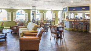 Un restaurante con mobiliario de madera, una zona de bar y ventanas amplias.