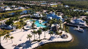 An aerial view of a resort with a large pool, palm trees, and a dock. - Luxurious Retreat in Naples Reserve! 3 Bedroom Pool House, unwind in style! (Naples)