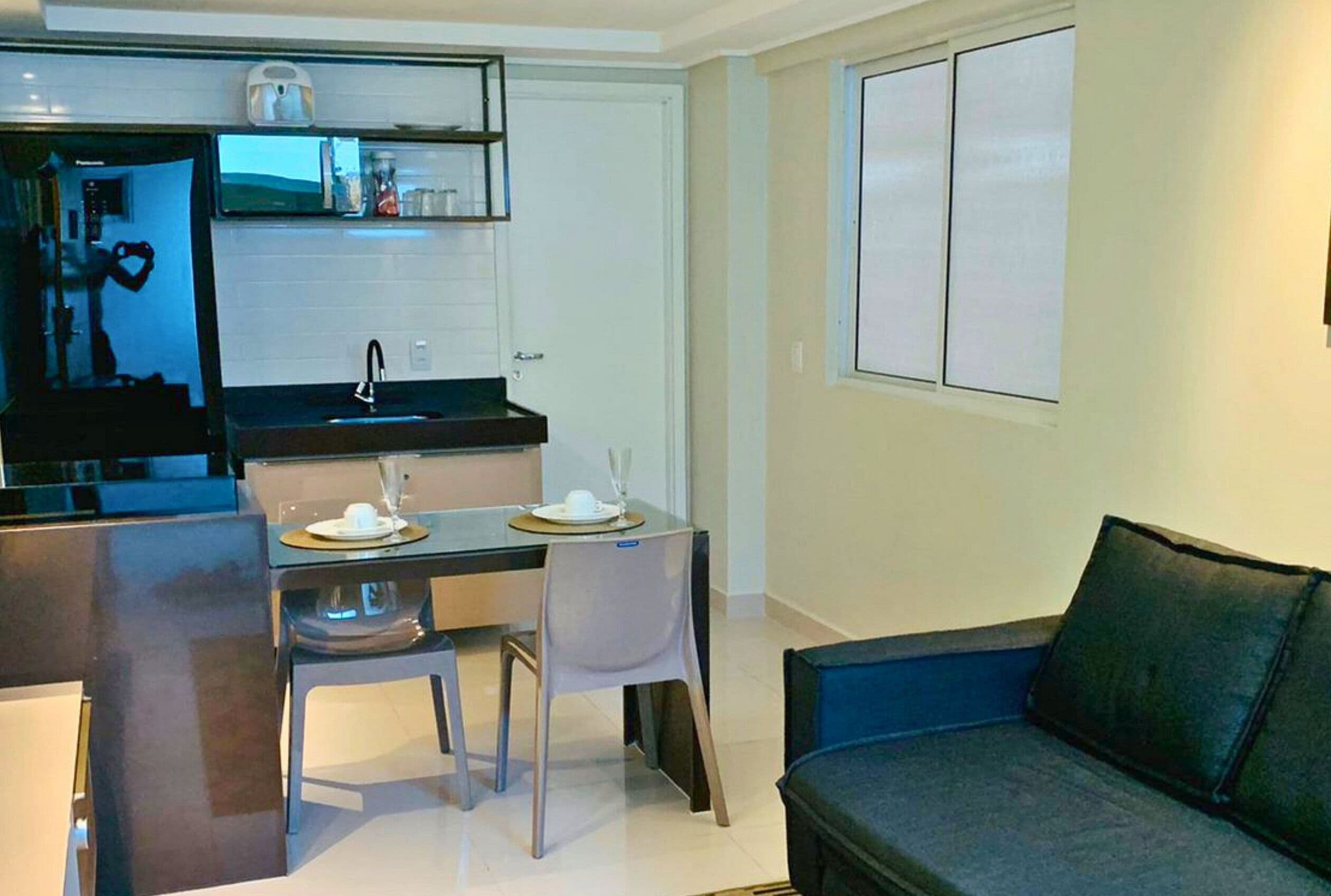 Un espacio habitable compacto con kitchenette, comedor y zona de estar.