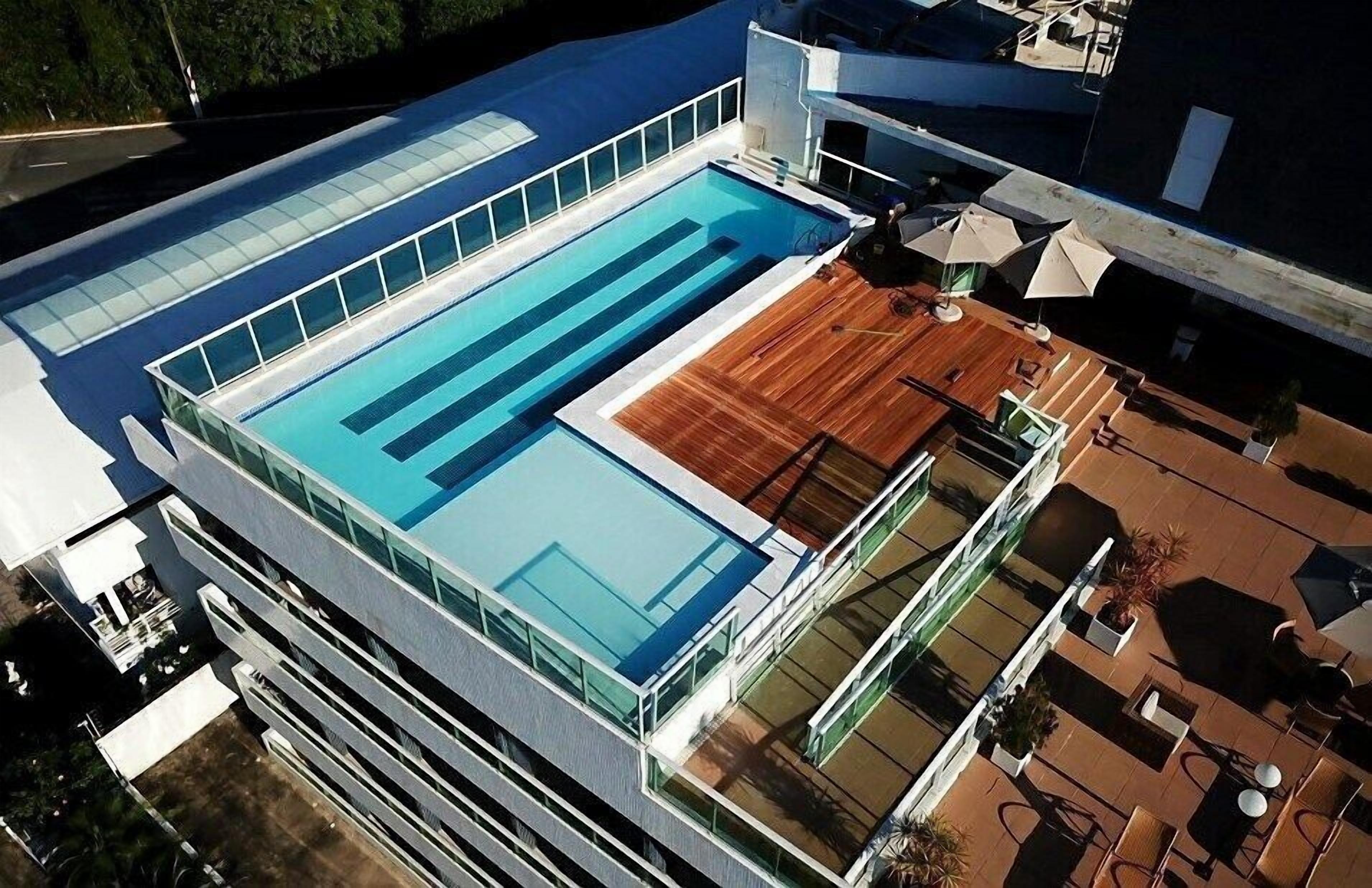 Ein modernes Gebäude mit Pool auf dem Dach und einer Sitzterrasse.