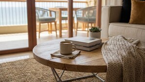 Een ronde houten tafel met een koffiemok, een boek en een kleine plant.