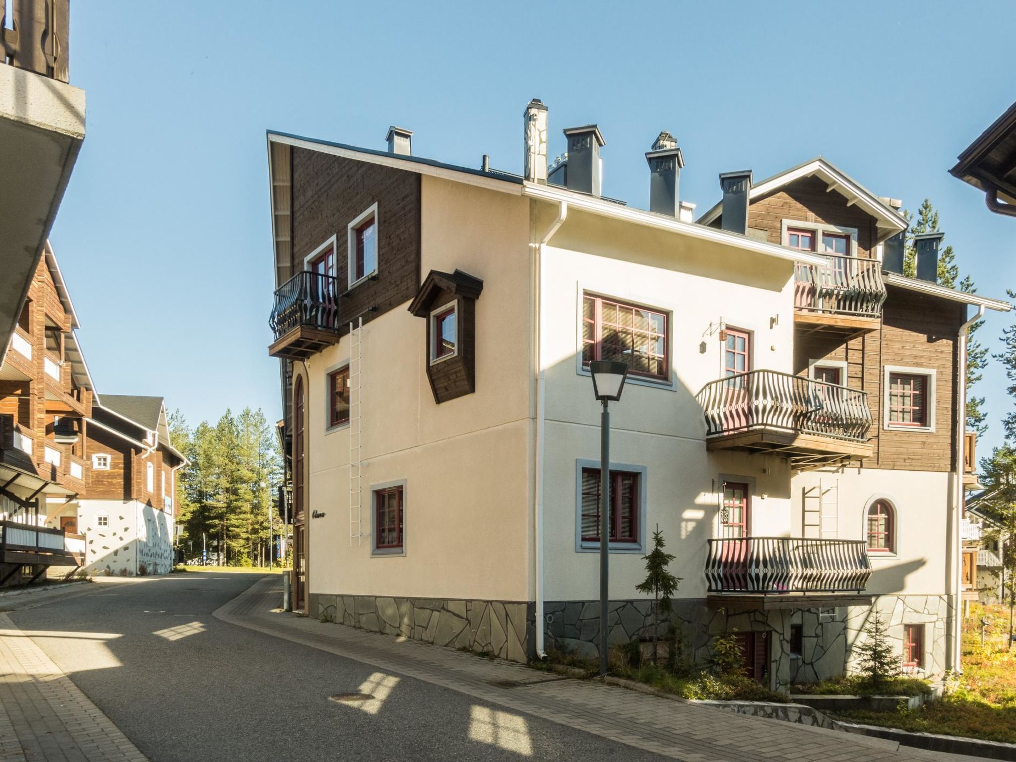 A multi-story building with balconies, a stone facade, and a clear sky.