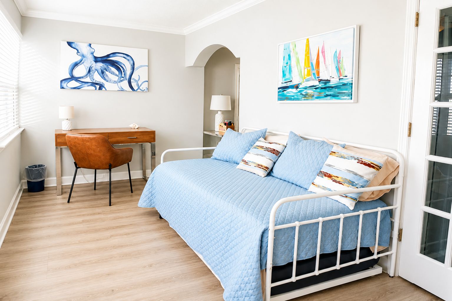 Une chambre à coucher avec un lit, un bureau et deux tableaux.