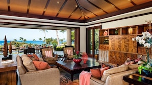 A spacious living area with a view of the ocean, furnished with sofas, chairs, and a coffee table. - Stunning Villa with Ocean Views, Pool, Home Theatre + Resort Amenities (Kamuela)
