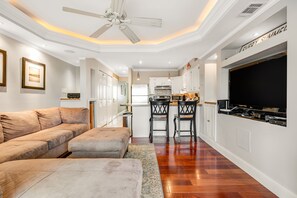 Relax in this stylish living space with a large sectional sofa, oven, and flat-screen TV.