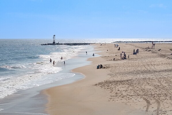 Guests can enjoy a serene beach experience with access to the ocean and a picturesque lighthouse in the distance.