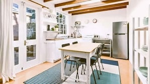 A modern kitchen with a dining table, chairs, and a refrigerator. - Historic 3-Bed 'Bostane Cottage' 5 minutes to City. (West Hobart)