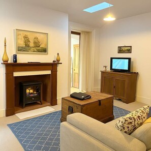 A living room with a fireplace, a television, and a sofa.