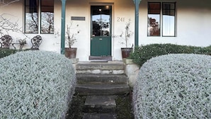 A building with a green door, the number 241, and a sign that reads "BOSTANE". - Historic 3-Bed 'Bostane Cottage' 5 minutes to City. (West Hobart)