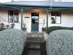 A building with a green door, the number 241, and a sign that reads "BOSTANE".