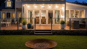 A two-story house with a large deck, outdoor seating, and a fire pit. - "Casa Con Vista" Luxury Waterfront Home-Sleeps 10. (Tranmere)