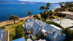 A coastal property with multiple houses, a view of the sea, and a mountainous backdrop. - "Casa Con Vista" Luxury Waterfront Home-Sleeps 10. (Tranmere)
