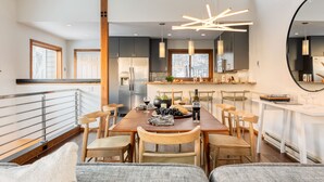 A modern kitchen with a dining area, featuring a large island, pendant lighting, and a view of the city. - Pandora by AvantStay | Modern Mountain Escape in Entrance of Bear Creek Trail (Telluride)